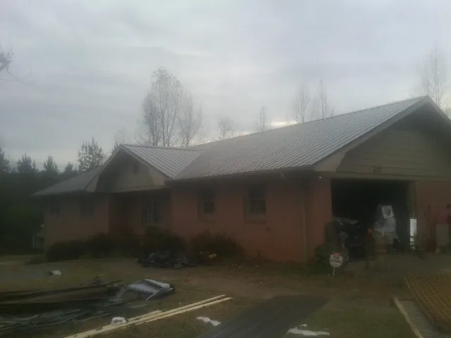 Gray metal roof on a stucco house with an attached garage in Jeffersonville