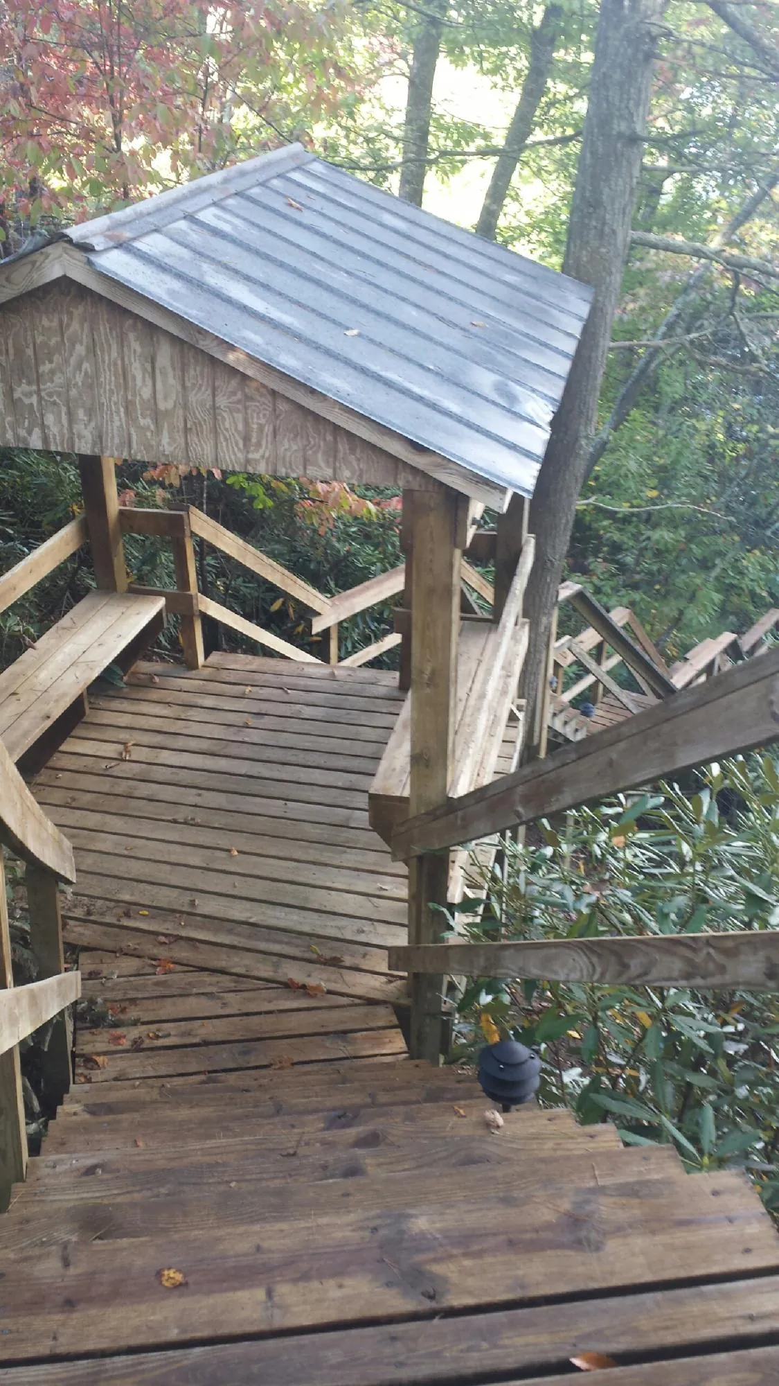 Metal roofed shelter over wooden steps on a wooded walkway — Skylight Repair & Installation work by our crew in Jeffersonville